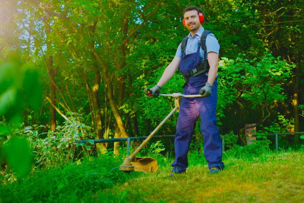 Gardener Using Edge Trimmer | 10 Essential Garden Tools To Complete Your Gardening Tool Kit