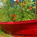 Freshly painted, Red dory, boat re-purposed, recycled, into flower and herb garden | Recycled Planters For Your Container Garden | featured