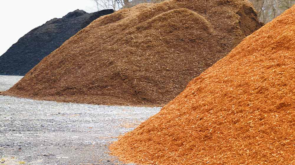 close up on colorful mulch in piles | Mulch Colors: How To Choose The Right One For Your Garden | colored mulch | featured