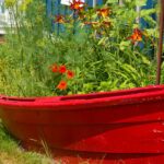 Freshly painted, Red dory, boat re-purposed, recycled, into flower and herb garden | Recycled Planters For Your Container Garden | featured