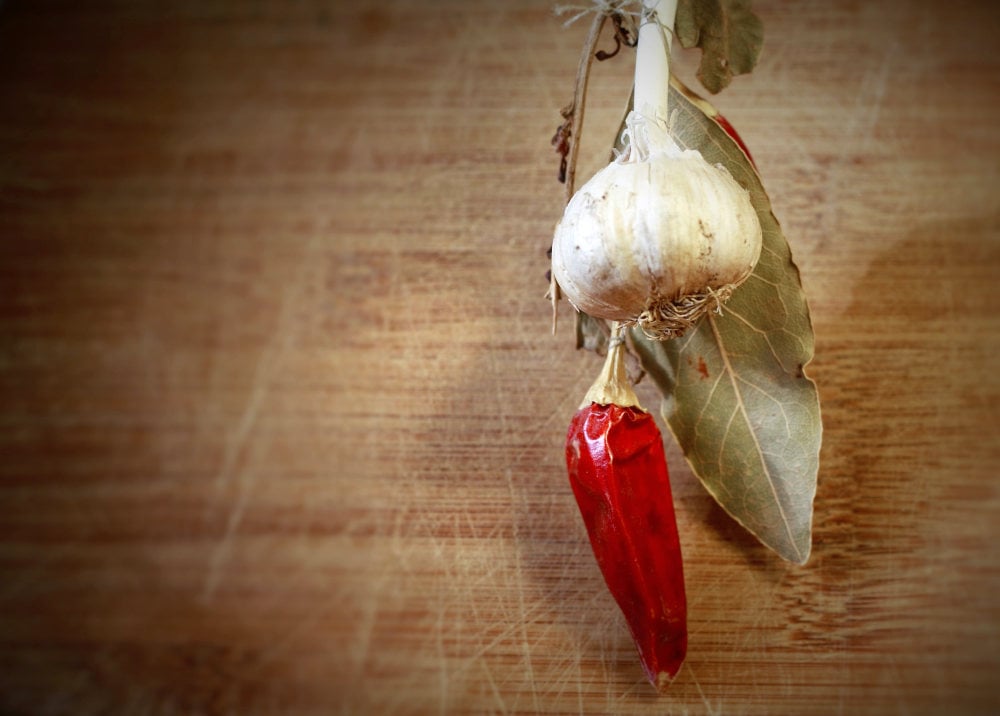 Chili and garlic on wooden background | The Best Homemade Dog Repellent For Your Garden | essential oil