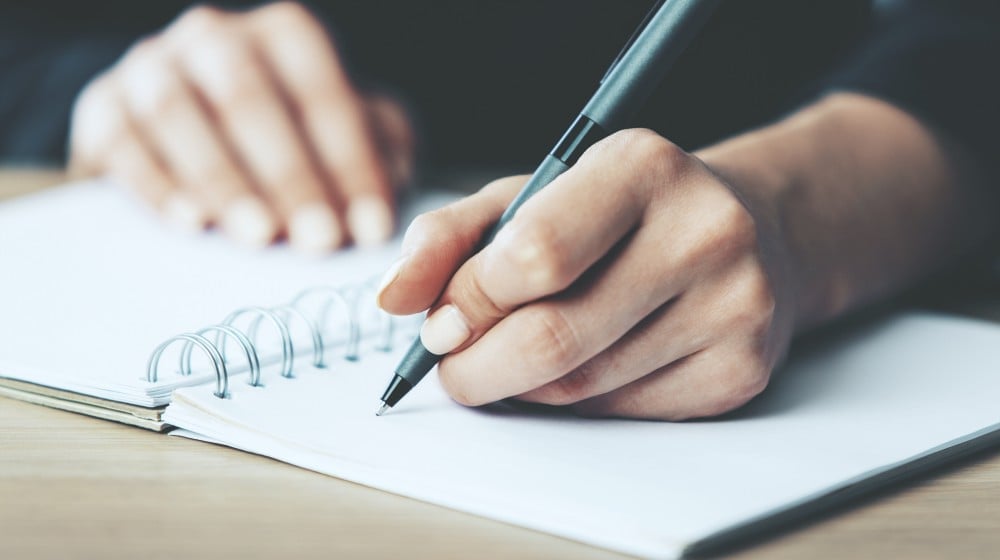 person writing on notebook | Small Garden Ideas And Tips | How To Design Gardens In Limited Spaces | small garden ideas | small garden