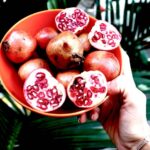 Person Holding Pomegranates | How To Store Pomegranate Seeds | Garden Season Tips | Featured