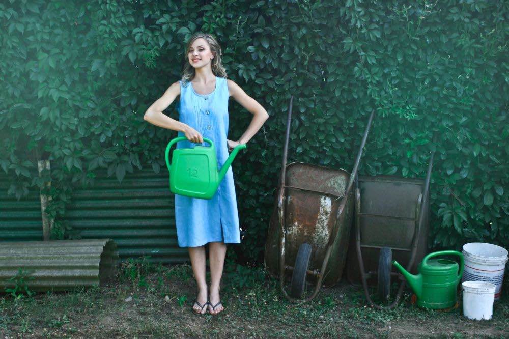 happy woman to water her garden | Pros And Cons Of Square Foot Gardening | Garden Season